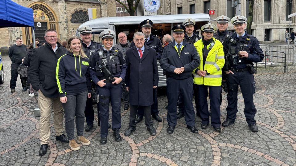 Viele Polizisten stehen vor dem Infostand der Polizei Bonn. Dazwischen Innenminister Herbert Reul und Polizeipräsident Frank Hoever.